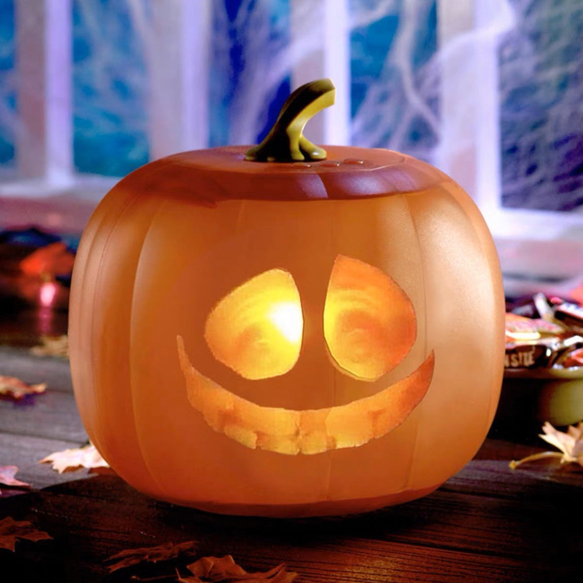 Talking and Singing Pumpkin Projector with a glowing interior on a Halloween-themed background